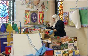 Kindergarten teacher Manal El-Sheikh looks for items that she can save from her classroom at the center.