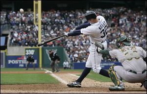 Detroit Tigers' Don Kelly hits a sacrifice fly to right to score teammate Omar Infante during the ninth inning of Game 2 of the American League division baseball series against the Oakland Athletics on Sunday.