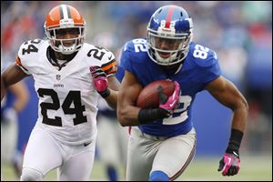 New York Giants wide receiver Rueben Randle (82) runs away from Cleveland Browns cornerback Sheldon Brown (24) during the first half of an NFL football game Sunday.