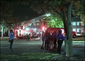 A ladder truck from the Toledo Fire and Rescue Department is used to reach the fire on the second floor of Campus Village.