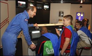 Flight director Reed Steele talks to Springfield 8th grader Nathan Thomas, standing, in the space station as part of the Fall STEM Challenge. The Educational Service Center (ESC) of Lake Erie West , sponsor of the Challenger Learning Center of Lake Erie West in Oregon, Ohio, is hosting the challenge.