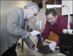 Bowling Green mayor Dick Edwards, left, and Mike Hammer, Public Works Superintendent for the city, open a time capsule.