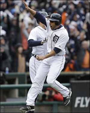 Detroit's Omar Infante high fives a teammate after scoring the game-winning run on a sacrifice fly by teammate Don Kelly during the ninth inning of Game 2 on Sunday. The Tigers beat Oakland 5-4.
