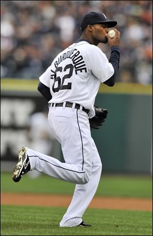 Detroit Tigers relief pitcher Al Alburquerque kisses the ball before throwing out Oakland Athletics Yoenis Cespedes at first base during the ninth inning of Game 2 of the American League division baseball series.
