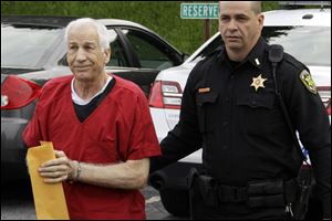 Former Penn State University assistant football coach Jerry Sandusky, left,  arrives for sentencing on child sex abuse charges at the Centre County Courthouse in Bellefonte, Pa.