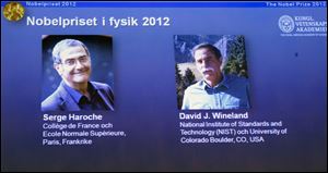Photographs of the 2012 Nobel Prize laureates in Physics Serge Haroche from France, left, and David Wineland from the U.S. are presented on a screen during a media conference at the Royal Swedish Academy of Science in Stockholm, Sweden.