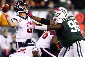Houston Texans quarterback Matt Schaub (8) throws a pass as he is rushed by New York Jets defensive end Muhammad Wilkerson (96) and linebacker Calvin Pace, obscured, during the first half of Monday night's game.