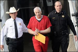 Jerry Sandusky is escorted from Centre County Courthouse after sentencing Tuesday.
