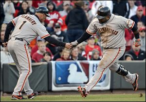 San Francisco Giants' Pablo Sandoval is congratulated by third base coach Tim Flannery after hitting a two-run home run Wednesday in Cincinnati.