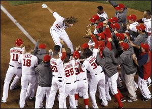 Washington Nationals' Jayson Werth leaps onto home plate after hitting a walk-off home run in the ninth inning against the St. Louis Cardinals.