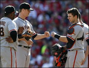 San Francisco Giants starting pitcher Matt Cain, center left, fist bumps catcher Buster Posey, right, as Cain was taken out in the sixth inning of Game 5.