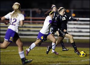 Perrysburg's Maddy Williams (12) breaks a way from  Maumee's Brynn Sautter. Williams' two goals in the game helped pace the Yellow Jackets to the NLL Championship.