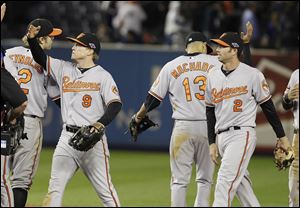Baltimore Orioles' Nate McLouth (9) and J.J. Hardy (2) celebrate with teammates Thursday after a 2-1 win over the Yankees in New York.
