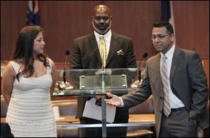 Alexis DeAnda Martinez, Toledo mayor Mike Bell, and Adam Martinez, thank guests in city council chambers at the conclusion of the ceremony.