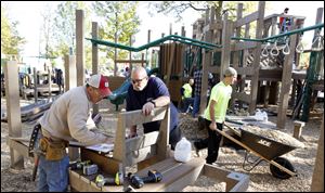 Volunteers Steve Roth, left, and Brock Cahill help build Imagination Kingdom, a $250,000 playground on the south side of Reighard Park in Wauseon.