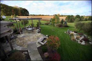 An artisan-made pergola sets off the backyard at the Maumee home of Catherine Gruenwald.