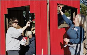 Volunteers Patty Boger, left, and Kay Young help build Imagination Kingdom.