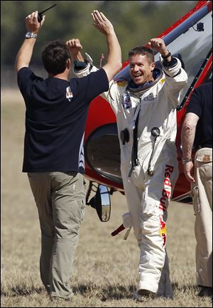 Felix Baumgartner, right, of Austria, celebrates with Luke Aikins, team skydiving consultant, after Baumgartner successfully jumped from a space capsule lifted by a helium balloon at a height of just over 128,000 feet above the Earth's surface, Sunday,  in Roswell, N.M.