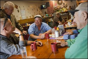 Jim Witker, center, laughs while other Pemberville residents welcome his son Arik Witker, left, home from his latest tour of duty in Afghanistan while the pair talk over breakfast at Janelle's diner in Pemberville.