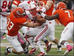 Bowling Green's Paul Swan, 33, and D.J. Lynch, 7, stop Miami's Spencer Treadwell at the line of scrimmage.
