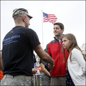 GOP vice-presidential nominee Paul Ryan, center, and his daughter  Elizabeth Ryan, 10, right, greet a member of the BGSU Pershing Rifles Company I-1 before the BGSU football game Saturday at Doyt L. Perry Stadium.