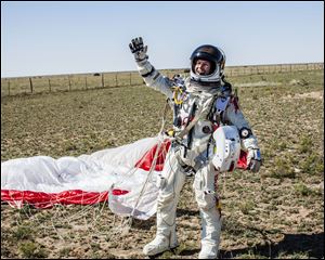 In this photo provided by Red Bull Stratos, Pilot Felix Baumgartner of Austria celebrates after successfully completing the final manned flight for Red Bull Stratos in Roswell, N.M., Sunday. Baumgartner came down safely in the eastern New Mexico desert minutes about nine minutes after jumping from his capsule 128,097 feet, or roughly 24 miles, above Earth.