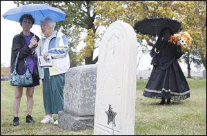 Dori Wolf, left, and Lois Helm-Webb, related to the Haughton family, listen to speakers. One of Ms. Helm-Webb’s ancestors, Ira Haughton, is among the Civil War veterans buried there.