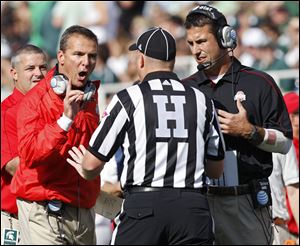 Ohio State Buckeyes head coach Urban Meyer and Luke Fickell yell at a referee during the 1st quarter against Michigan State Spartans in the NCAA college football game at Spartan Stadium in East Lansing, Michigan on Sept. 29.