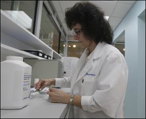 Najwa A. Kassem, R.Ph., filling a prescription at her new pharmacy.