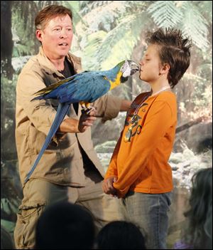 Animal handler Mike Kohlrieser prompts a bird to kiss Starr Elementary student Rhianna Blossom, 10, during a Rain Forest show at Coy Elementary School in Oregon.