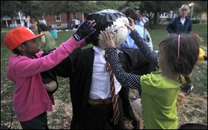 Emily Woodard, left, and Leela Cromwell, 9, both of Bowling Green, put a Harry Potter head on top of their scarecrow during a scarecrow workshop at the Wood County Historical Center in Bowling Green.
