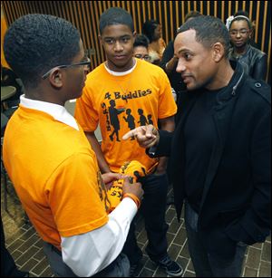 Rogers High School student Brandon Jackson, left, and Southview's Dannie Duhart speak with CSI: NY actor and author Hill Harper.