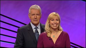 Jeopardy host Alex Trebek stands next to Stephanie Jass after she won more than $147,000 on the quiz show. Jass is an associate professor from Michigan.
