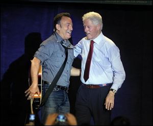 Bruce Springsteen, left, and former President Bill Clinton embrace after Clinton introduced Springsteen onto the stage at a Democratic rally at Tri-C Western Campus in Parma on Thursday. 
