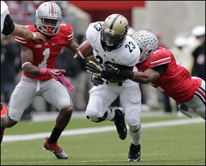 Purdue running back Ralph Bolden, center, runs the ball between Ohio State defensive back Bradley Roby, left, and defensive back Christian Bryant during the second quarter of an NCAA college football game Saturday.