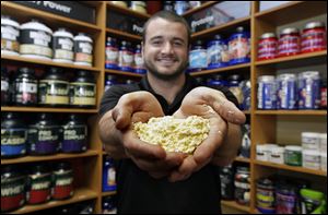 Ryan Dorn, a sales associate at Elite Nutrition in Milwaukee, Wisconsin, holds banana-flavored whey protein. The protein-rich product is being incorporated into more food products.