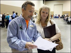 An employer talks with an applicant Wednesday at the 2012 Job & Career Fair at Seagate Convention Centre,