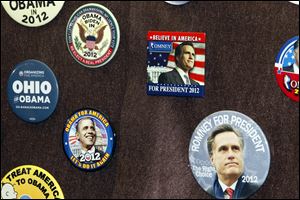 A collection of political buttons on display features Obama and Romney prominently in front of the display case at the Elyria Public Library.