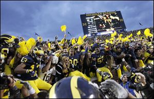 Michigan players celebrate in the student section.