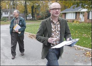 Denis Eble, left, and Evan Morrison head down Brookhurst Road in Sylvania as they go door to door on behalf of President Obama's re-election campaign. Crystal Bowersox also campaigned for the President last weekend.