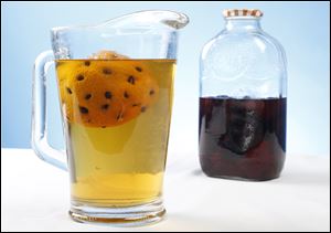 Vodka infused with a coffee bean spiked orange along with a bottle of vodka infused with plums.