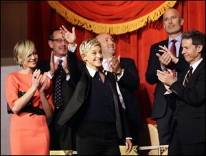 Entertainer Ellen DeGeneres, second from front left, waves as she is introduced, with wife Portia de Rossi, left, Monday before DeGeneres receives the 15th annual Mark Twain Prize for American Humor at the Kennedy Center.