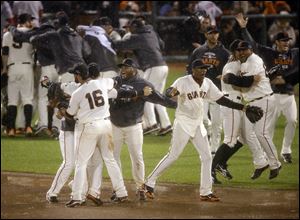 The San Francisco Giants celebrate after the final out in Game 7 of baseball's National League championship series against the St. Louis Cardinals.