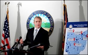 Ohio Auditor Dave Yost goes over the School Attendance Data Interim Report during a press conference in his Columbus office.