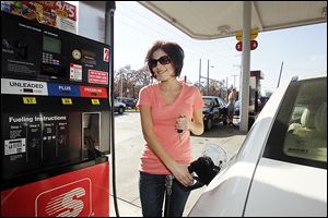 Tori Turner, of Sylvania Township, tops off her tank at the Speedway at Laskey and Secor in Toledo. Gas prices have fallen to below $3.00 per gallon at several  stations in Toledo