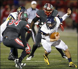 Whitmer’s Nick Holley tries to elude Central Catholic's Ian Butler. Holley rushed 22 times for 122 yards and two touchdowns. He threw for two more touchdowns.