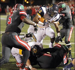 Whitmer running back Tre Sterritt (12) scores a touchdown against Central Catholic's Paul Moses (5) and Chris Green (45).