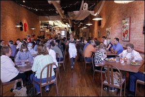 Jennifer Shemak, center, carries a to a table during the busy lunch hour at  Grumpy's.