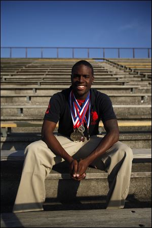 Michael Lipkins proudly shows off the medals he has won as a track athlete at Rogers High School. Running has been his way of avoiding trouble.