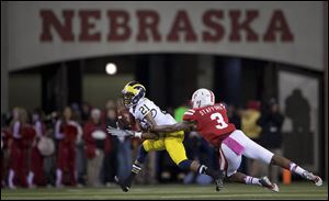 Michigan's Roy Roundtree pulls in a reception in front of Nebraska's Daimion Stafford during the first half Saturday in Lincoln, Neb.